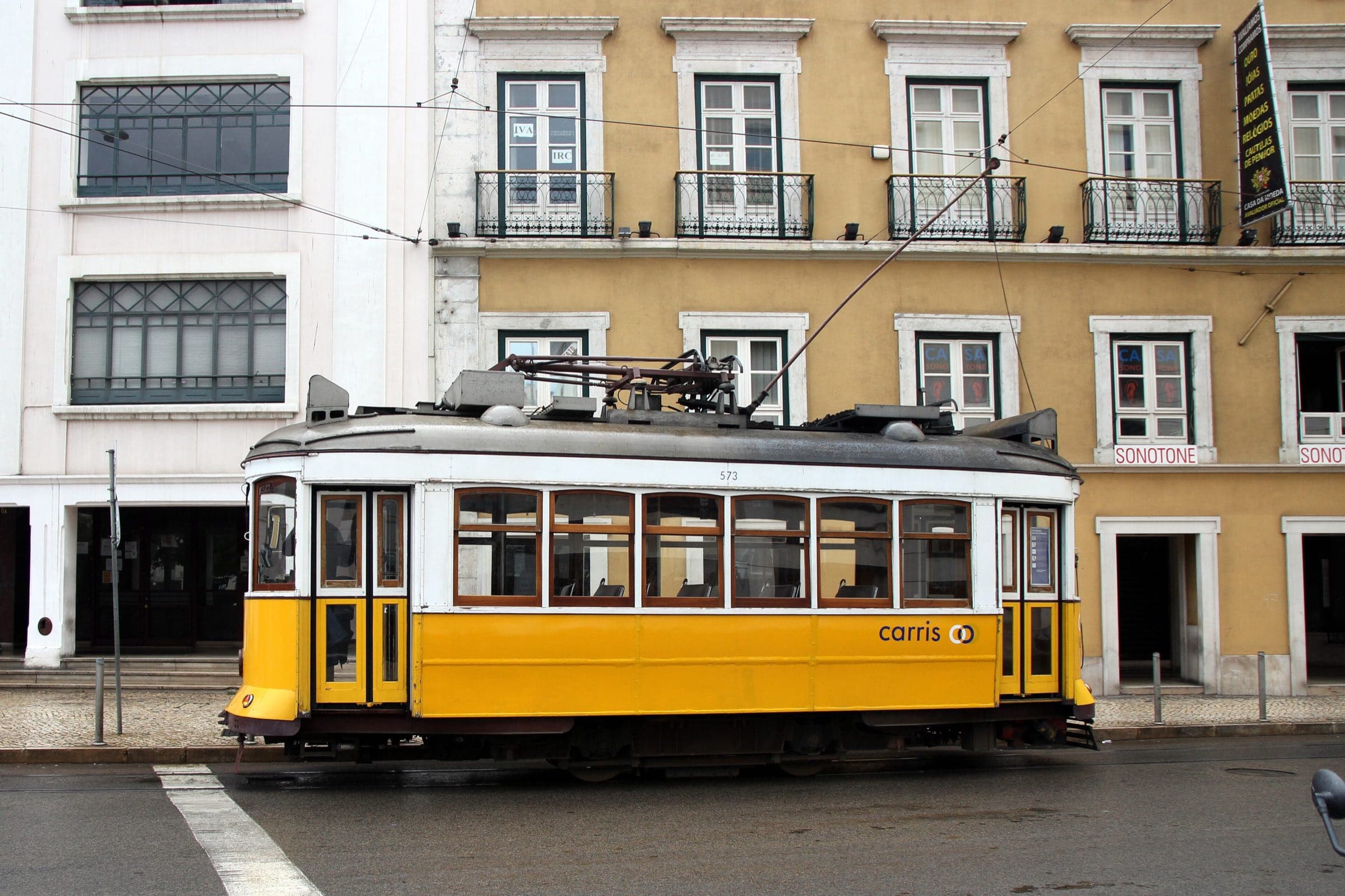 A tram on a tiled Lisbon street in warm light