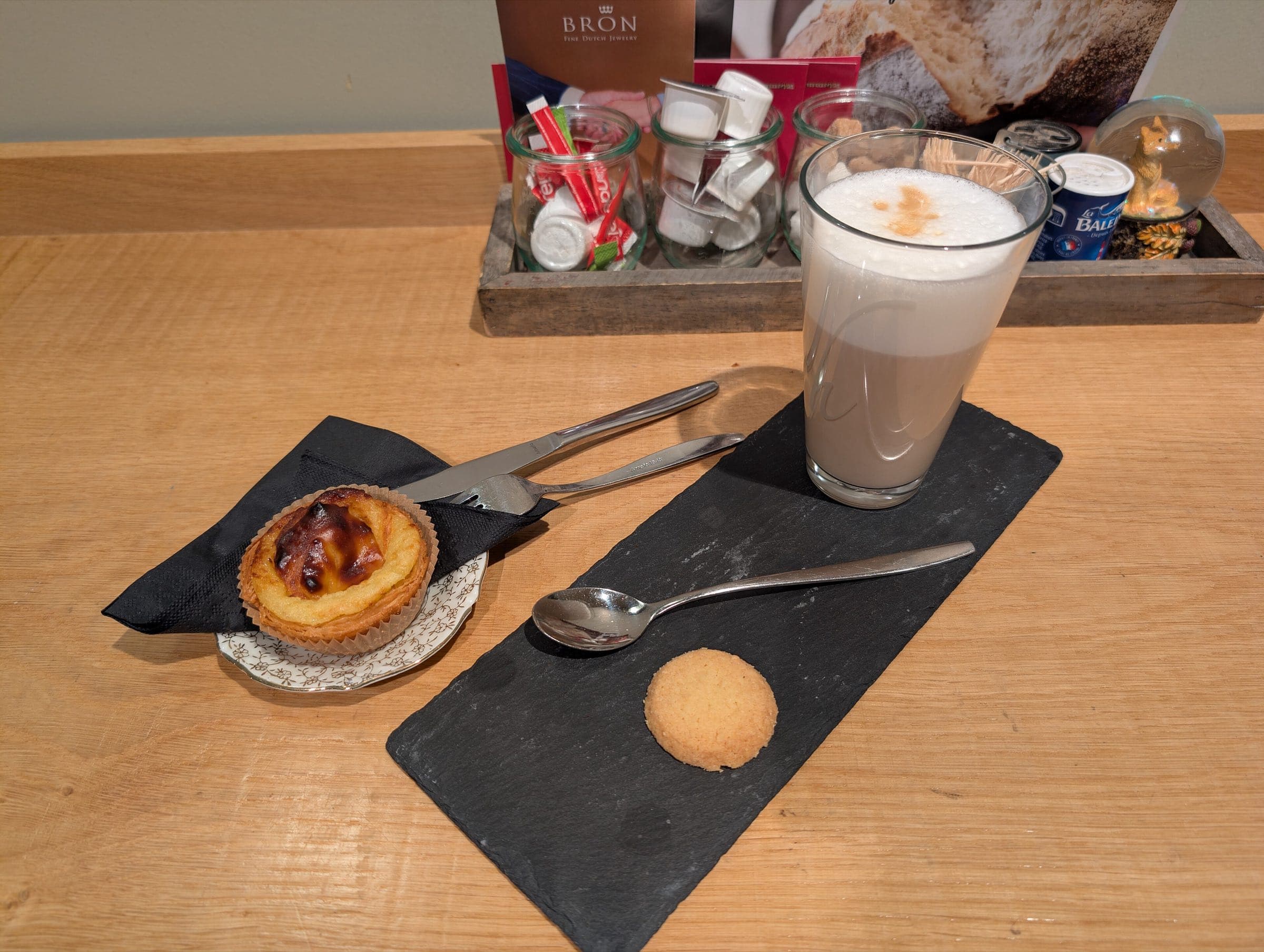 A pastel de nata and coffee on a cafe table